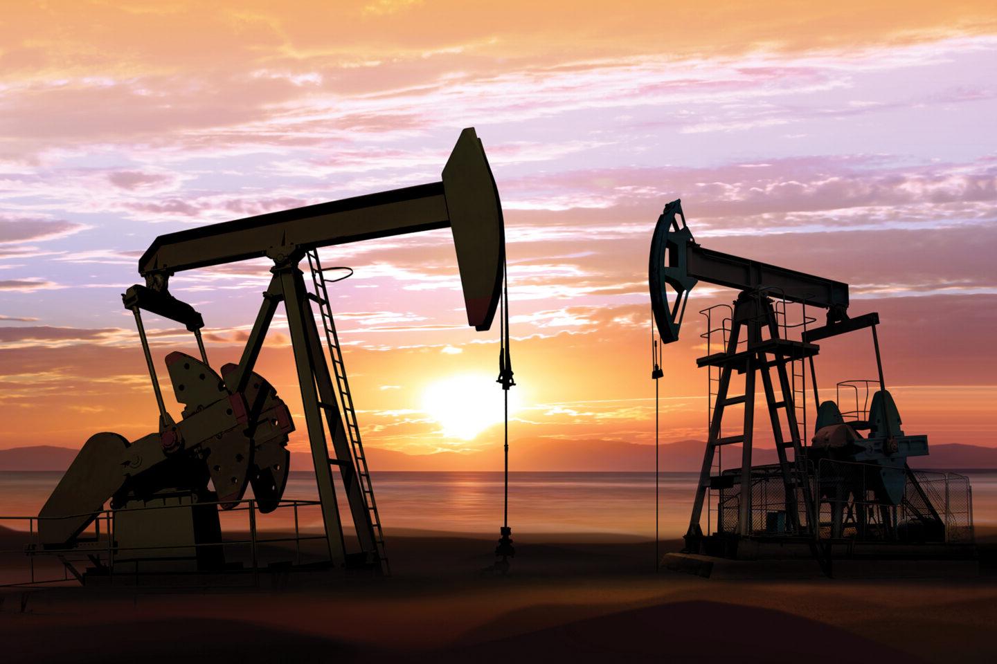 silhouette of working oil pumps on sunset background