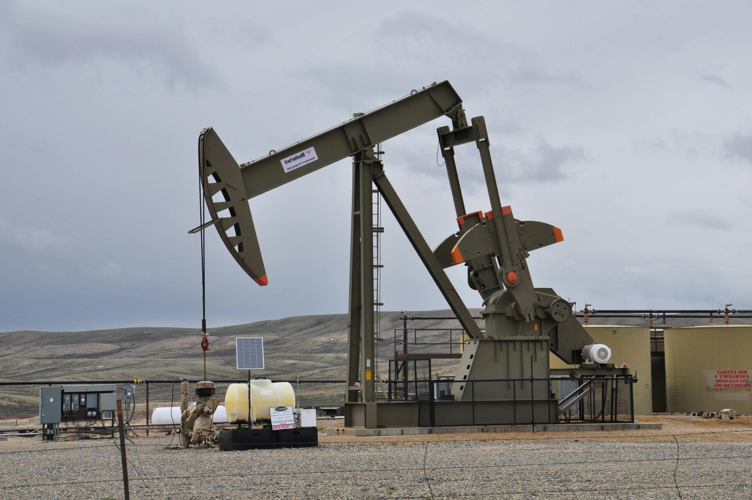 An image of an oil rig operating in an open field